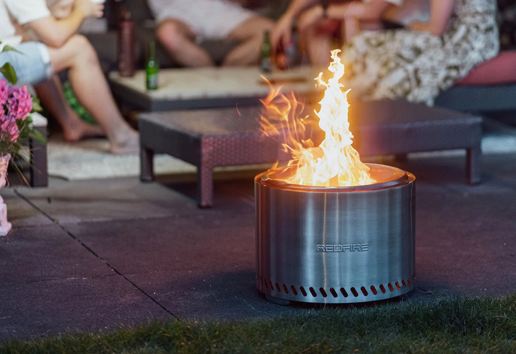 Un foyer de feu cylindrique élégant en acier inoxydable avec un design moderne et le nom de marque « redfire » gravé sur son côté.