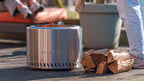 Foyer d’incendie cylindrique en acier inoxydable avec un design élégant et moderne, et le nom de marque « redfire » gravé sur son côté.