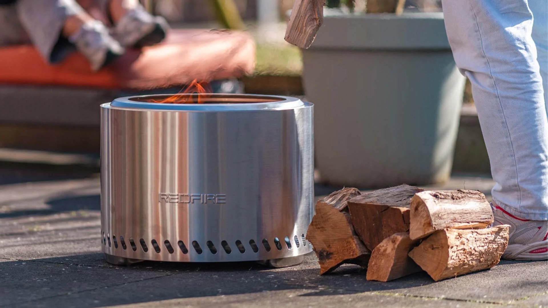 Foyer d’incendie cylindrique en acier inoxydable avec un design élégant et moderne, et le nom de marque « redfire » gravé sur son côté.
