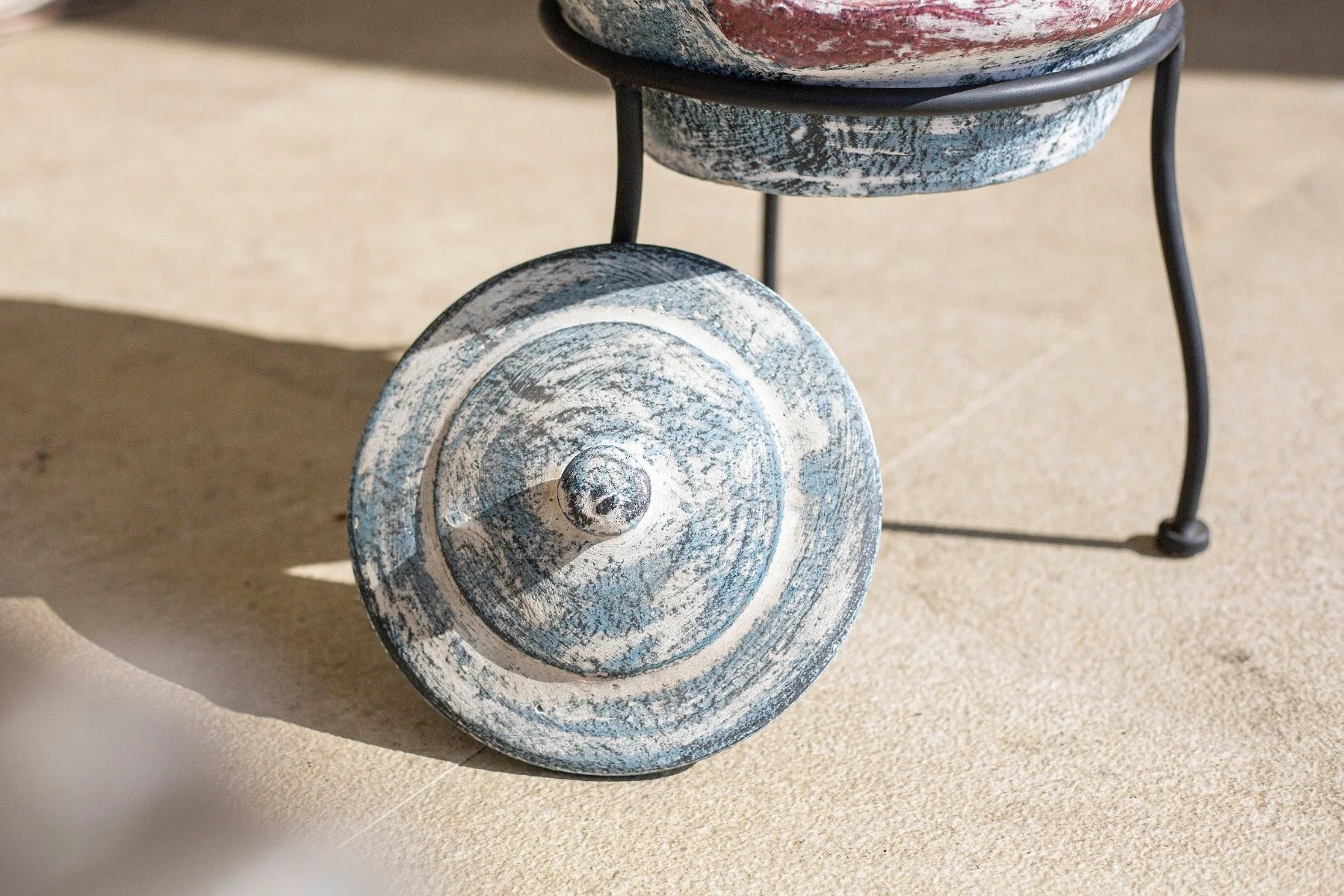 Couvercle de pot en céramique bleu et blanc patiné avec des motifs circulaires concentriques.