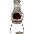 Chimineia en argile grise patinée avec un relief orné de motifs de feuilles et un support en métal noir.