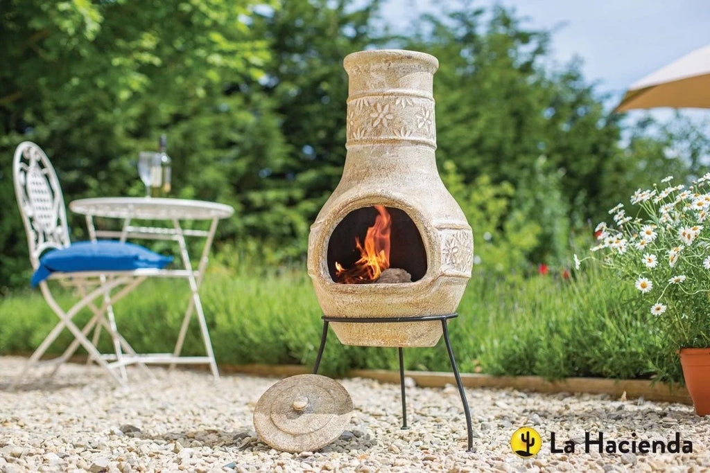 Cheminée en terre cuite avec motifs floraux sculptés et un feu brillant à l’intérieur.