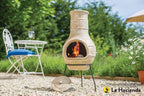 Cheminée en terre cuite avec motifs floraux sculptés et un feu brillant à l’intérieur.