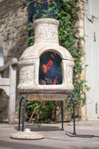 Cheminée en pierre avec motifs floraux sculptés et un feu chaud et lumineux à l’intérieur.
