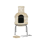Une cheminée en céramique rustique, blanc cassé, ornée de motifs floraux sculptés et d’un intérieur noir, reposant sur un support en métal noir.