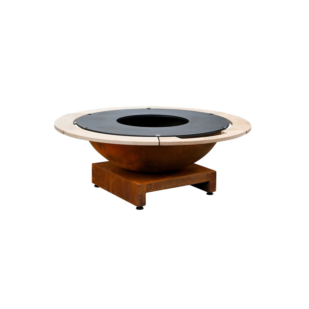 Foyer de feu rustique de couleur cuivre avec une surface de cuisson circulaire noire et des accents en bois clair.