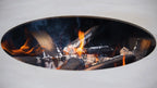 Un insert de cheminée ovale blanc moderne avec un feu brillant qui brûle à l’intérieur, comportant des bûches et des braises.