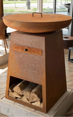 Foyer de feu en acier rouillé à teinte cuivrée avec un couvercle rond et un tiroir, conçu pour un usage extérieur.