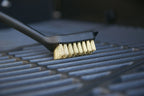 Brosse à gril noir et or avec des poils pour le nettoyage