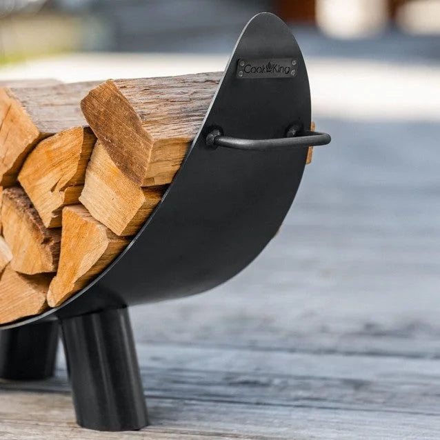 Porte-bûches en métal noir avec design courbé et poignée pour un transport facile.