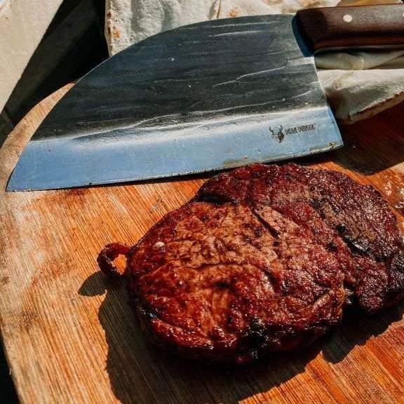 Couteau de chef de 20 pouces avec un manche noir et une lame en acier inoxydable.