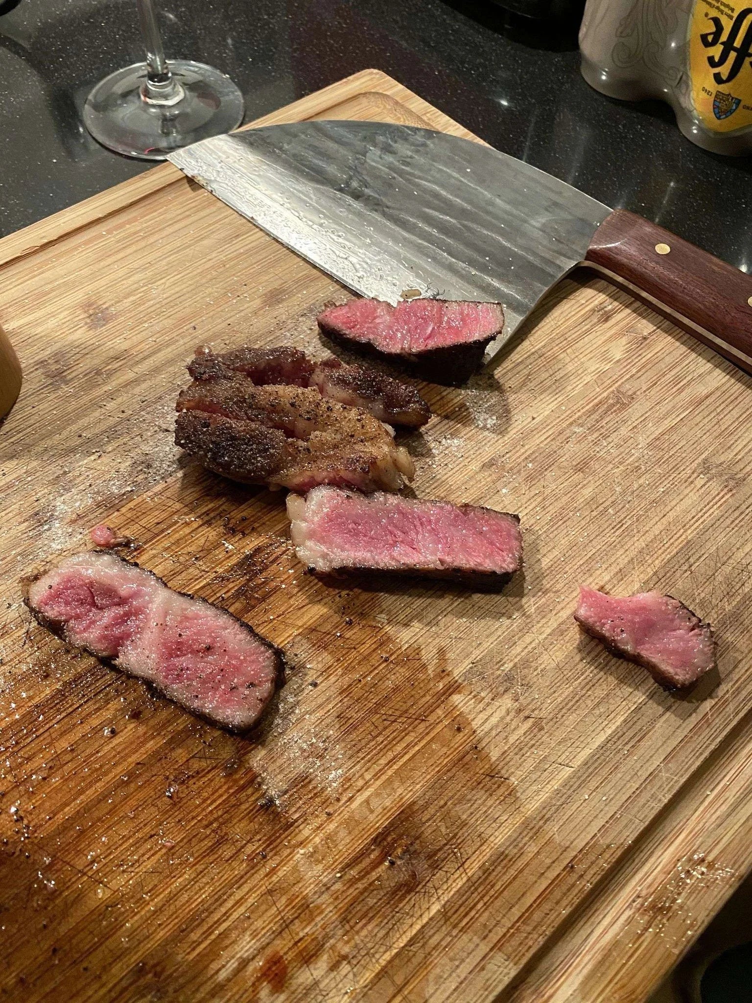 Planche à découper en bois avec couteau et viande tranchée.