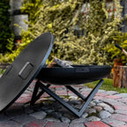 Barbecue au charbon avec couvercle noir et pieds en métal, conçu pour la cuisson en extérieur.