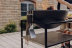Bol en fonte noire avec anses, conçu pour la cuisson en extérieur.