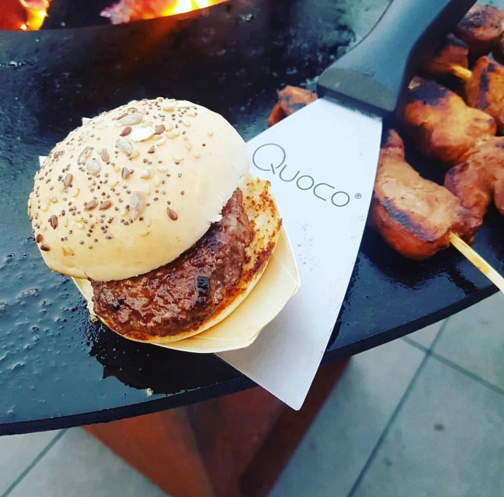 Un burger de bœuf juteux avec un pain grillé légèrement semé repose sur une doublure en papier de marque.
