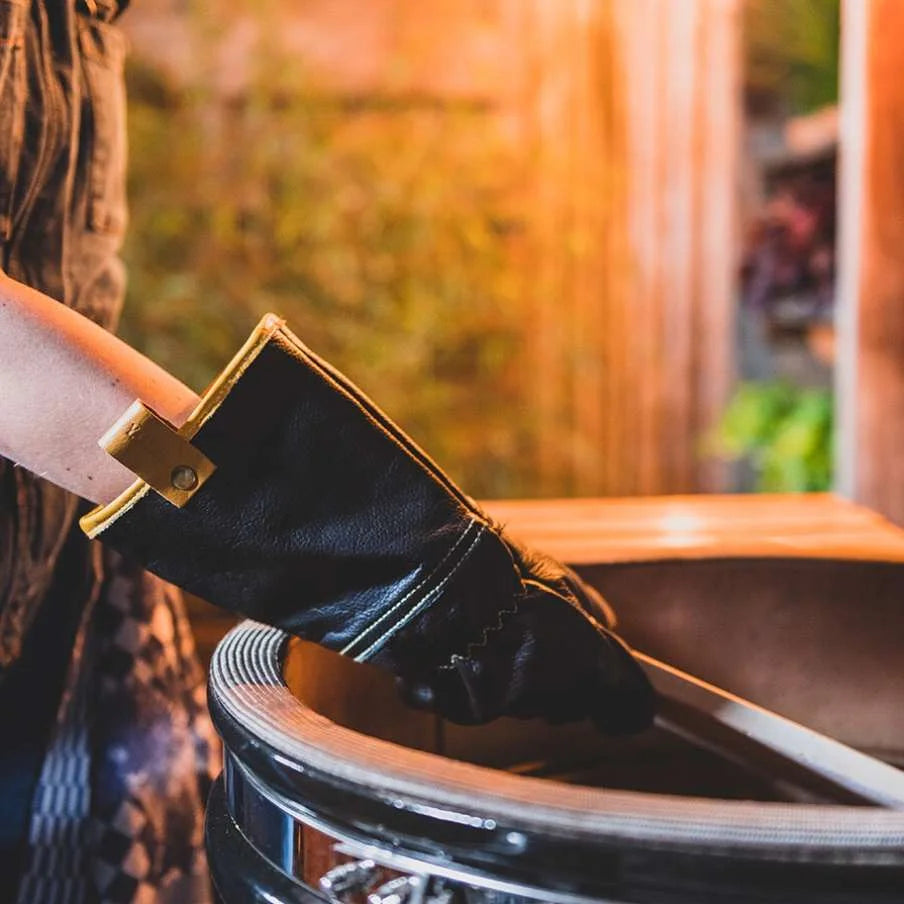 Botte en cuir noir avec boucle dorée et semelle blanche.