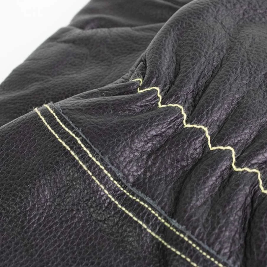 Gant en cuir noir avec coutures jaunes et surface texturée.