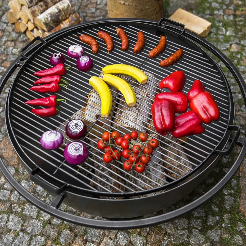 Barbecue grill ronde noire avec des poignées et divers aliments dessus.