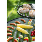Gril de barbecue avec diverses viandes et légumes en train de cuire dessus.