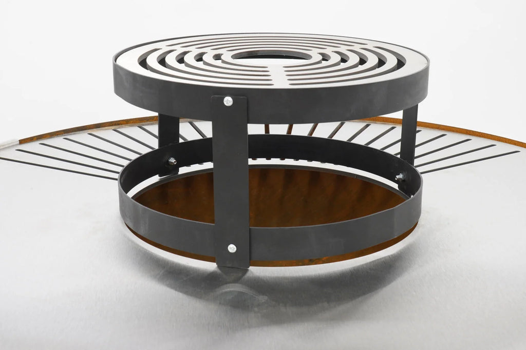 Foyer d’incendie en spirale noire avec grille métallique et base en bois.