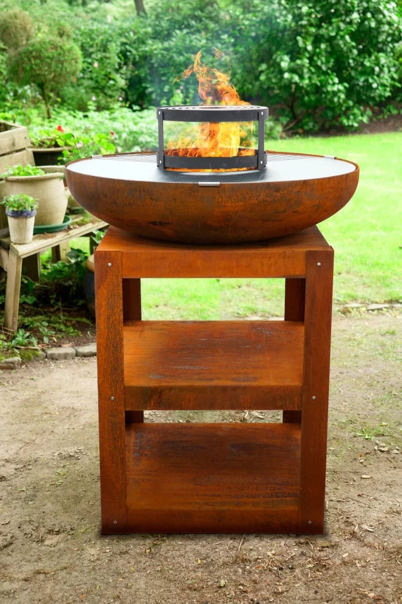Bol en acier Corten avec support en bois et flamme ouverte.