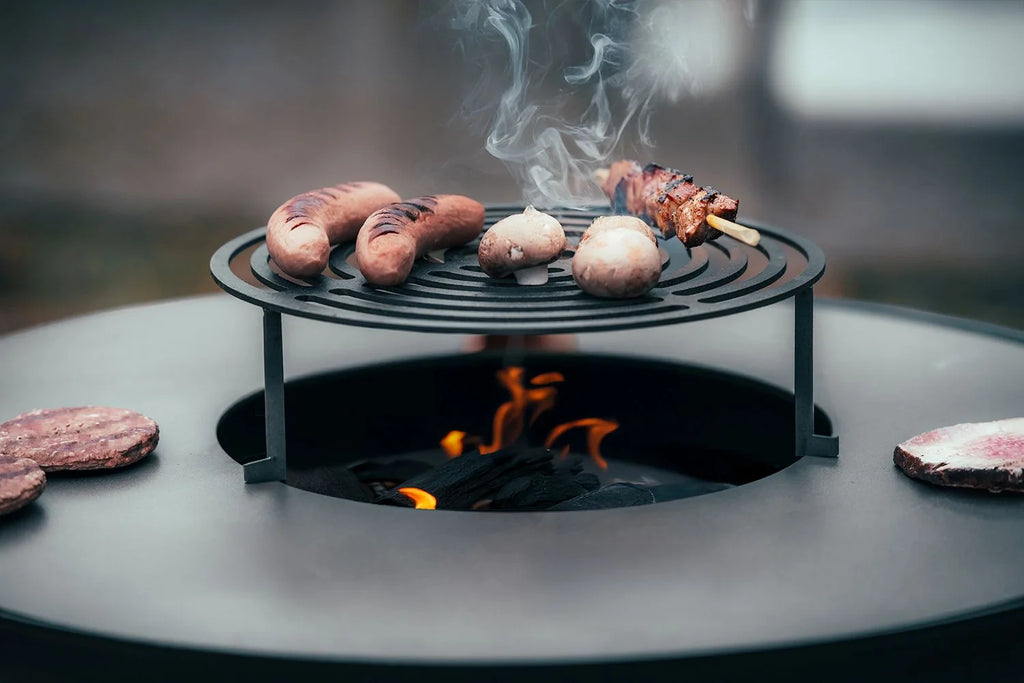 Grille de cuisson acier ronde Ø80 cm pour plancha Onyx 80 avec saucisses et champignons sur braises