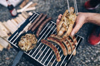 Gril de barbecue avec des saucisses et des oignons grillés.