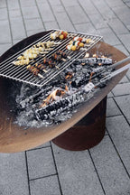 Barbecue au charbon avec grille en métal et base en bois.
