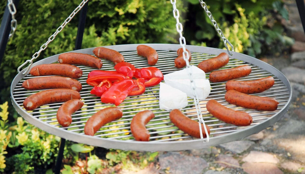 Barbecue grill avec design suspendu et grille en métal, mettant en vedette des saucisses et des poivrons rouges.