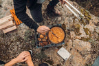 Poêle en fonte avec un manche rustique et un couvercle, présentant une sauce orange-brun