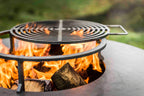 Foyer de feu en métal noir avec grille circulaire et poignée, doté d’un cadre robuste conçu pour une utilisation en extérieur.