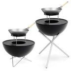 Gril noir en forme de bol avec des pieds en métal et un wok à manche en bois sur le dessus, inspiré du design Kambrook.