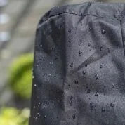 Housse en tissu imperméable noir avec une texture matelassée et de petits trous de drainage espacés uniformément.