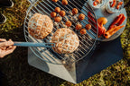 Barbecue au charbon avec grille en métal et poignée, corps noir, accents argentés.
