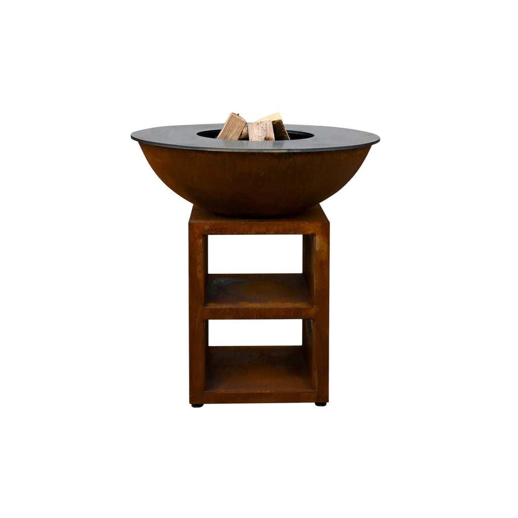 Bol en cuivre rouillé de couleur cuivrée avec un couvercle en pierre noire, reposant sur un support en bois assorti.