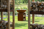 Foyer de feu en bol de cuivre rustique avec une base en bois et des étagères de rangement