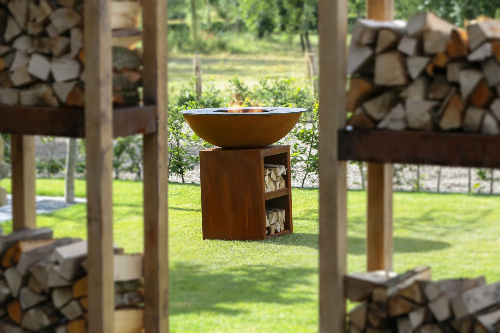 Foyer de feu en bol de cuivre rustique avec une base en bois et des étagères de rangement