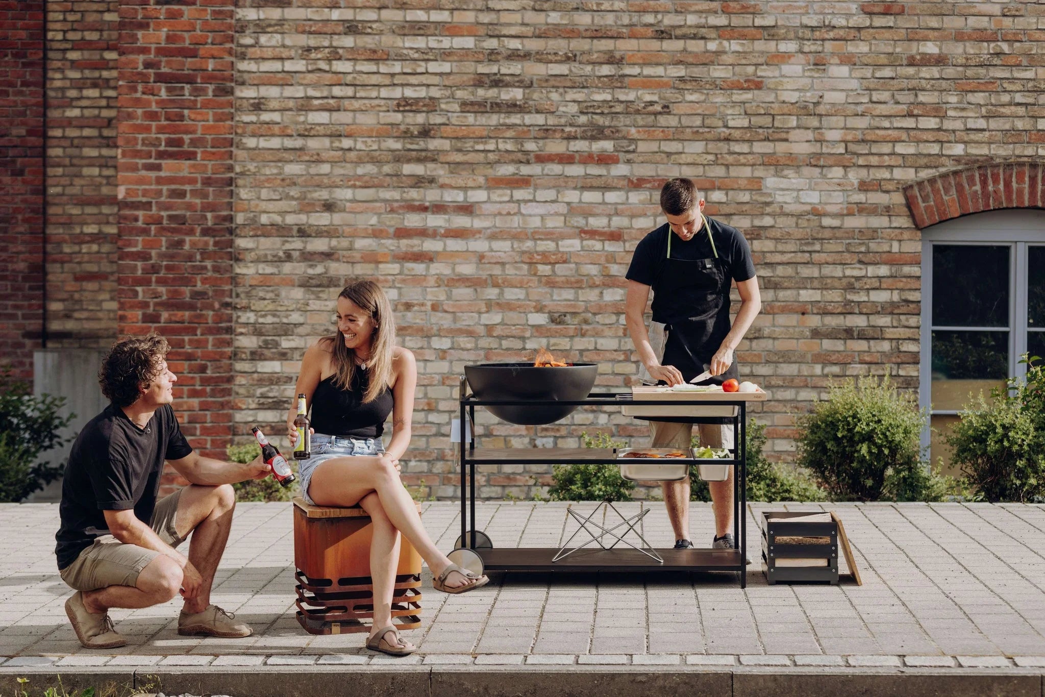 Gril noir avec roues et une surface de cuisson, probablement de Weber.