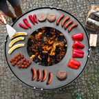 Barbecue au charbon avec design circulaire et arrangement vibrant de nourriture.