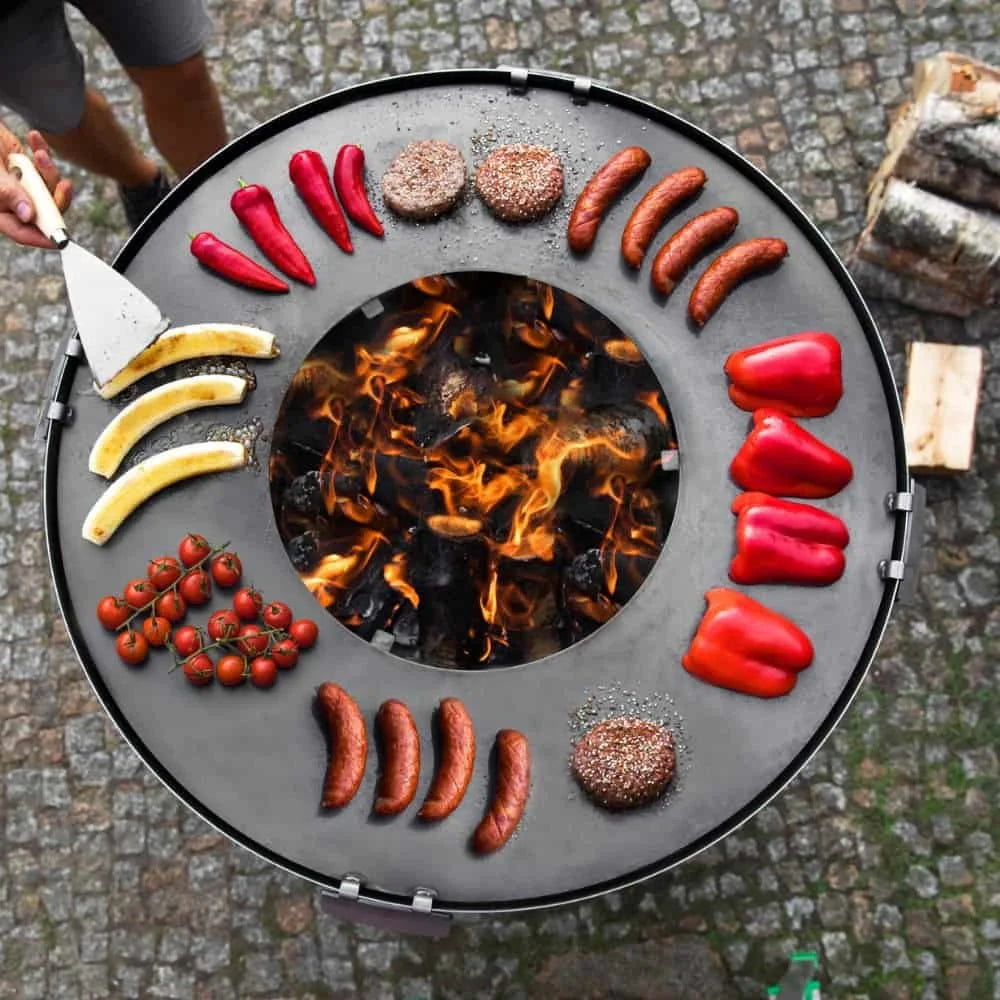 Barbecue au charbon avec un design circulaire et une disposition vibrante de nourriture.