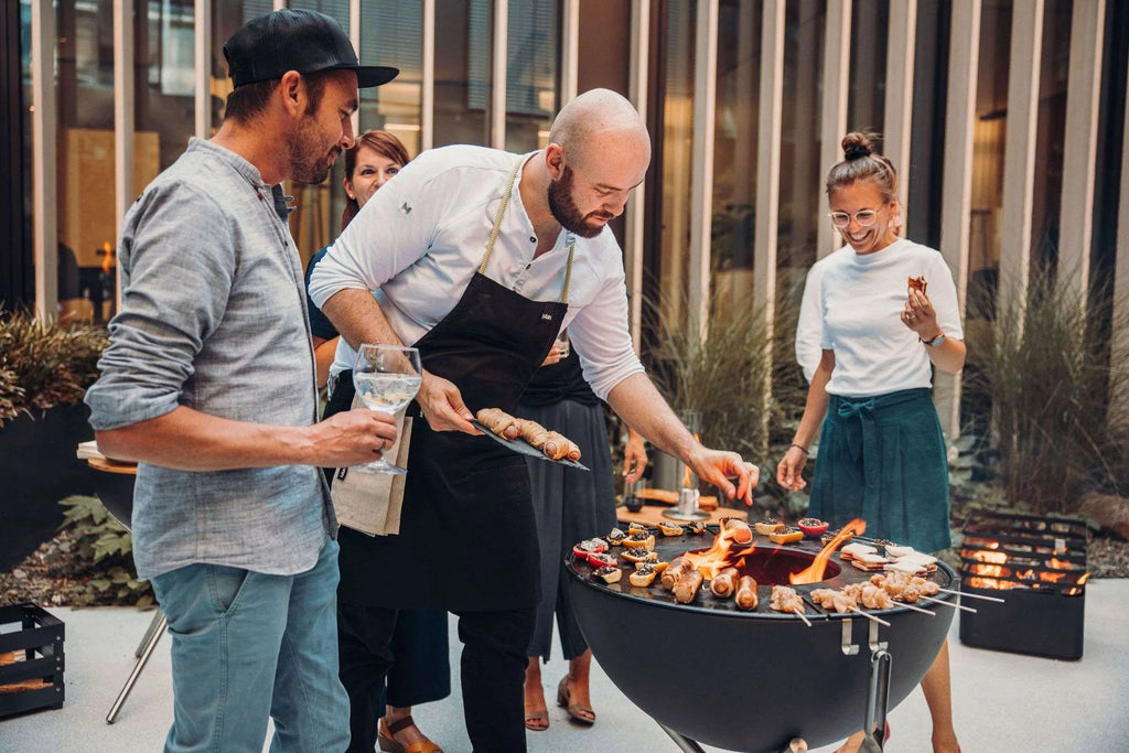 Barbecue au charbon avec bol noir et grille argentée.
