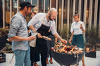 Barbecue au charbon avec bol noir et grille argentée.