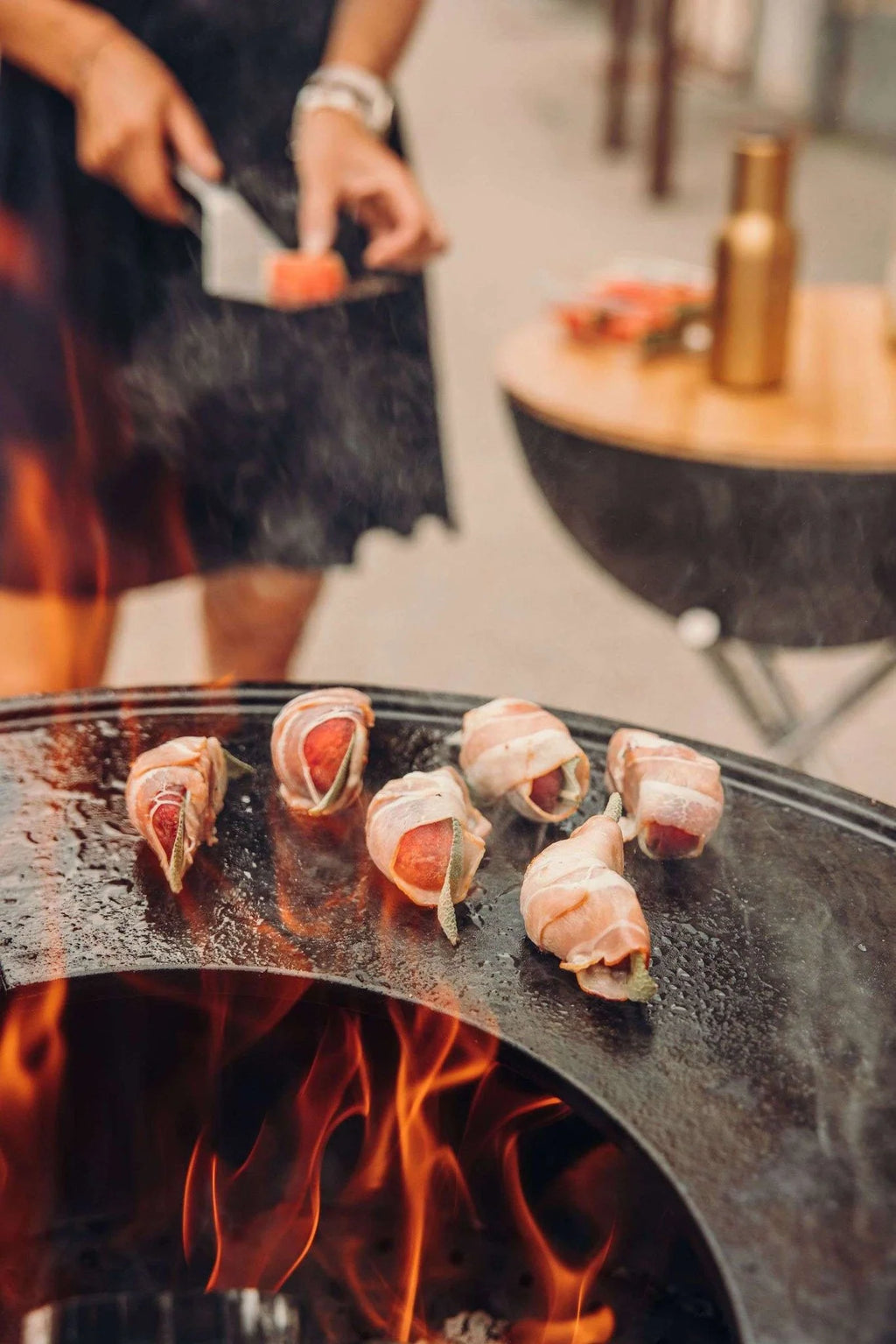Barbecue au charbon avec braises incandescentes et viande enveloppée de bacon.