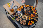 Barbecue rond de 24 pouces au charbon avec finition noire et grille en métal.