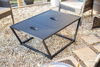 Table basse en métal noir avec deux tiroirs et poignées intégrées.