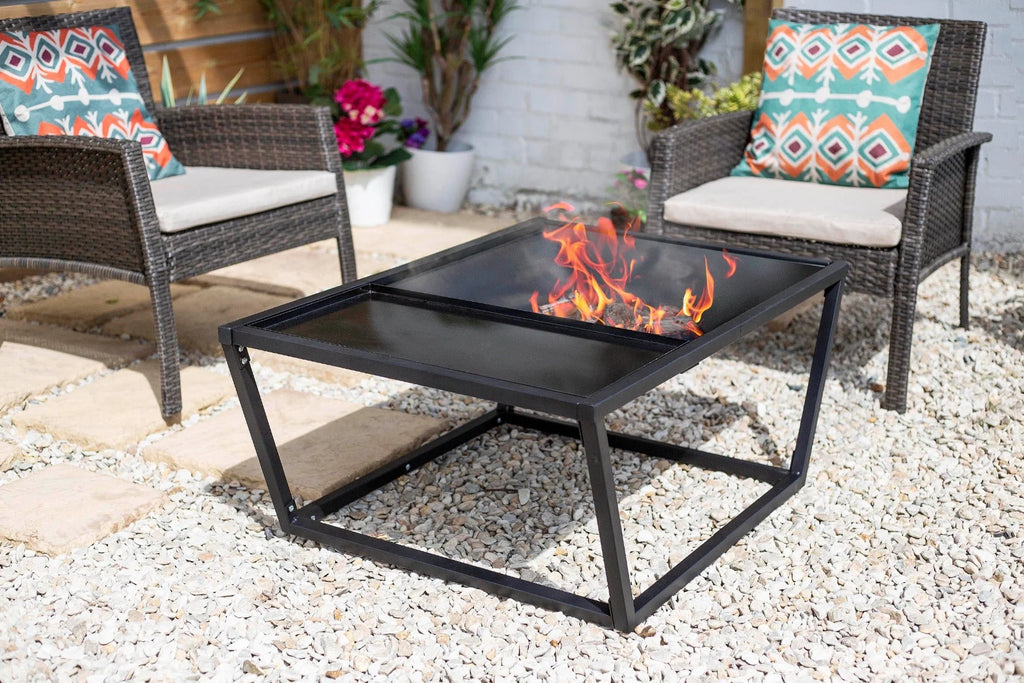 Table de feu en métal noir avec plateau en verre et flammes visibles