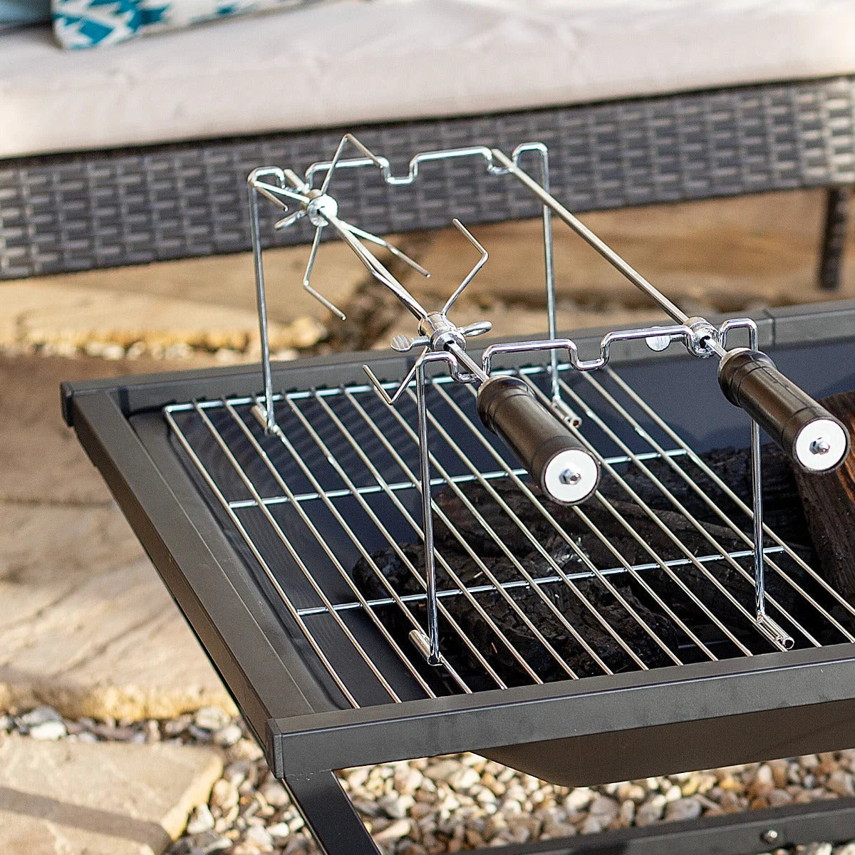 Gril rotative en métal argenté avec poignées en bois et un mécanisme de rotation central.