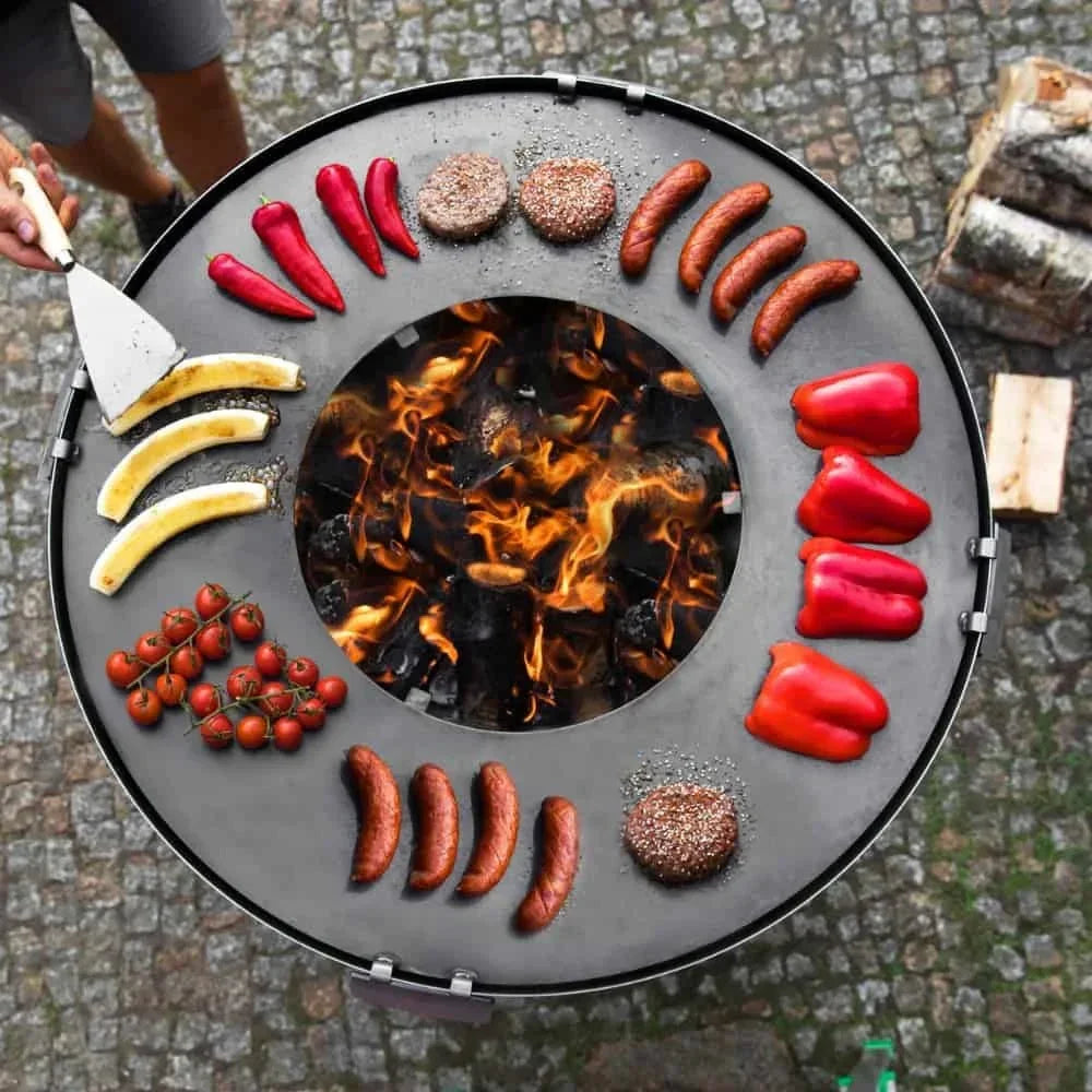 Barbecue au charbon avec design circulaire et arrangement vibrant de nourriture.