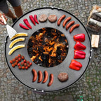 Barbecue au charbon avec design circulaire et arrangement vibrant de nourriture.