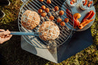 Barbecue au charbon avec grille ronde et poignée en métal.